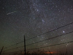 FILE - A meteor streaks through the sky.