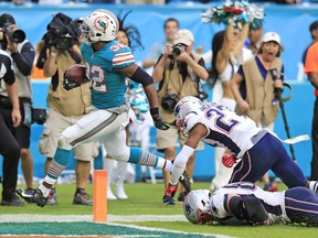 Miami Dolphins running back Kenyan Drake (32) scores to defeat the New England Patriots at Hard Rock Stadium in Miami Gardens on Sunday, Dec. 9, 2018. (Al Diaz/Miami Herald via AP)