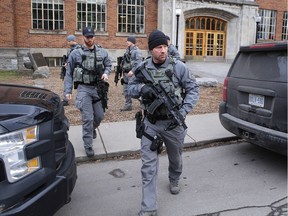 Kingston police officers walk out of Kingston Collegiate and Vocational Institute after an online threat was made to the school in Kingston, Ont. on Thursday, Nov. 6, 2018.