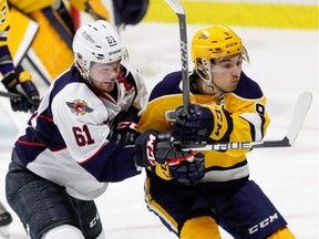 Kyle Maksimovich (9) battles with the Spitfires' Luke Boka during the Otters' game at Windsor on Dec. 13.