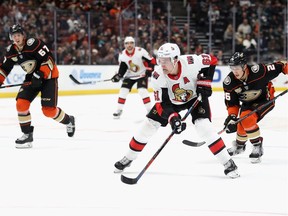 Mark Stone of the Ottawa Senators splits the defence of Brandon Montour #26 and Rickard Rakell #67 of the Anaheim Ducks during the overtime period of a game at Honda Center on Wednesday, Jan. 9, 2019.