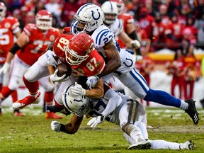 Travis Kelce #87 of the Kansas City Chiefs is tackled by J.J. Wilcox #37 and teammate Kenny Moore #23 of the Indianapolis Colts during the first quarter of the AFC Divisional Round playoff game at Arrowhead Stadium on January 12, 2019 in Kansas City, Missouri. (Photo by Peter Aiken/Getty Images)