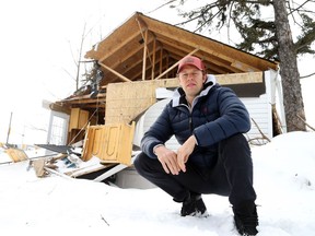 Chris Kushneriuk, a former minor-pro hockey player who has twice battled cancer, poses for a photo in front of his house, which was damaged by a tornado on Sept. 21.