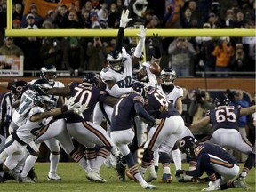 FILE- In this Jan. 6, 2019, file photo, Chicago Bears kicker Cody Parkey (1) boots a field goal-attempt during the second half of an NFL wild-card playoff football game against the Philadelphia Eagles in Chicago. Eagles' Treyvon Hester (90) tipped Parkey's attempt just enough to send the ball bouncing off the upright and crossbar, securing a 16-15 win at Chicago in the wild-card round.