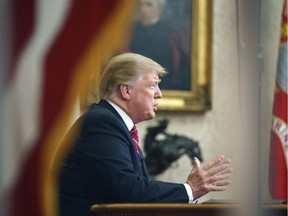 As seen from a window outside the Oval Office, U.S. President Donald Trump gives a prime-time television address.