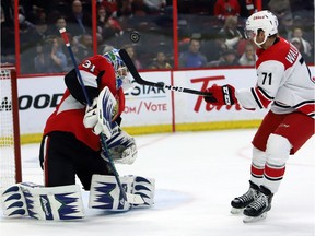 Ottawa Senators goaltender Anders Nilsson makes a shoulder save as Carolina Hurricanes' Lucas Wallmark looks on during second period NHL hockey play in Ottawa on Sunday.