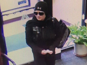 A woman is seen in a screenshot from surveillance video at the Fall River Municipal Credit Union in Fall River, Mass.