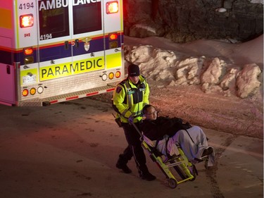 A patient is taken to an ambulance as first responders attend to victims of a horrific rush hour bus crash at the Westboro Station near Tunney's Pasture.