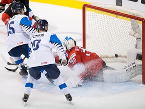 Finland's Aleksi Heponiemi looks on as teammate Aarne Talvitie sends a shot past Switzerland goalie Luca Hollenstein during first period IIHF world junior semifinal hockey action in Vancouver, Friday, Jan. 4, 2019.