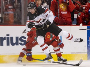 Brett Leason of Canada tries to sidestep a bodycheck from Saveli Olshanski of Russia in Group A hockey action of the 2019 IIHF World Junior Championship on Dec., 31, 2018 at Rogers Arena in Vancouver.