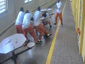In this screenshot taken from a Southern Ohio Correction Facility security camera video four inmates, handcuffed to a table, are attacked by a fellow prisoner who slipped his handcuffs and brandished a knife, Sunday, June 4, 2017, at the Southern Ohio Correctional Facility in Lucasville, Ohio.