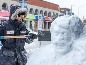 Mowafak Nema sculpts a lumberjack in front of the Chateau Lafayette in the ByWard Market in celebration of their 170 years in business, as the region prepares for Winterlude.