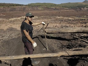 Tereza Ferreira Nascimento pauses as she digs in search of the body of her missing brother Paulo Giovane Santos, with her garden tools, days after a dam collapse in Brumadinho, Brazil, Wednesday, Jan. 30, 2019.
