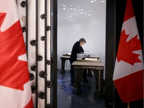 Parliament Hill post office worker Angèle Ouellet takes a few quiet moments to view the Books of Remembrance on Tuesday. The books carry the names of all Canadian soldiers who have lost their lives since the First World War.