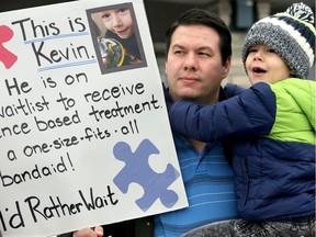 Marc Mailhot and his son, Kevin, 4, and a sign that says it all. On Friday, for the second time in a week, about 40 protesters showed up at MPP Lisa McLeod's Barrhaven office to protest against the changes made to funding for autistic children.