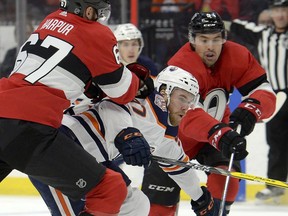 The Edmonton Oilers' Connor McDavid is tied up by the Ottawa Senators' Ben Harpur (67) and teammate Cody Ceci during the first period at the CTC on Thursday, Feb. 28, 2019.