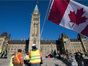 Men wear  yellow vests and wave the Canadian flag on Parliament Hill before the planned  Convoy for Canada truck protest in Ottawa, Ontario, on February 19, 2019.