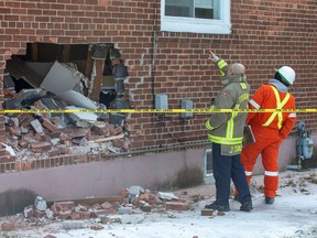 Emergency responders check out the gaping hole left in the side of a bungalow on South Woodrow Blvd. in Scarborough after two men in a stolen 'bobcat' bulldozer slammed into the home. (John Hanley photo)
