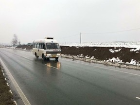 An ambulance drives on a highway, travelling from the direction of a large explosion, in Pampore, Indian-controlled Kashmir, Thursday, Feb. 14, 2019.