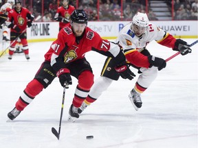Ottawa Senators centre Chris Tierney skates the puck past Calgary Flames defencemen Mark Giordano during the second period NHL hockey, Sunday night.