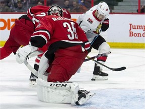 Hurricanes goaltender Curtis McElhinney (35) looks on as Senators centre Jean-Gabriel Pageau (44) deflects the puck off his skate towards the net during the second period. The puck crossed the line, but the apparent goal was disallowed after an NHL video review.
