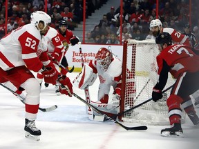 The Detroit Red Wings' Jonathan Ericsson (52) defends as goaltender Jonathan Bernier (45) blocks a wraparound attempt by the Ottawa Senators' Brady Tkachuk (7) during the second period at the CTC on Saturday, Feb. 2, 2019.