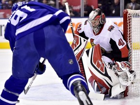 Ottawa Senators goaltender Craig Anderson keeps his eyes on the puck as Toronto Maple Leafs centre John Tavares looks for the shot.