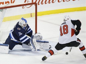 The Ottawa Senators' Ryan Dzingel scores the game-winning goal against Winnipeg Jets goaltender Laurent Brossoit during overtime in Winnipeg on Saturday, Feb. 16, 2019.