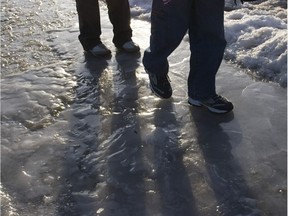 Youngsters walk along an icy sidewalk.