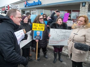 Parents protest in front of MPP Lisa MacLeod (right) outside her constituency office in Barrhaven on Feb. 8, 2018, claiming that the recent funding announcement for autistic children is not nearly enough. (Wayne Cuddington/ Postmedia)