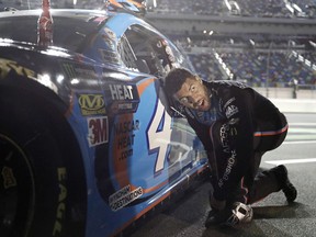 Darrell Wallace Jr. adjusts his driving shoes before getting into his car before the first of two qualifying auto races for the NASCAR Daytona 500 at Daytona International Speedway, Thursday, Feb. 14, 2019, in Daytona Beach, Fla.