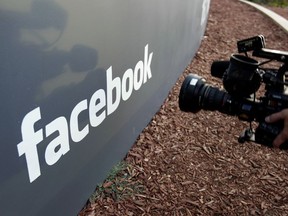 In this May 18, 2012, file photo a television photographer shoots the sign outside of Facebook headquarters in Menlo Park, Calif.