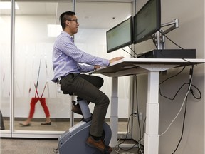 Ryan Wong works while riding a stationary bike at the Public Service Commission in Gatineau Friday Sept 7, 2018. The public service commission features stationary bike and treadmill desks, part of an active workstations pilot project now a few years in the making.