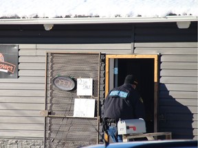 A Mohawk police officer enters Wild Flower Cannabis Dispensary during a raid on it and another dispensary on Feb. 5 in Akwesasne.