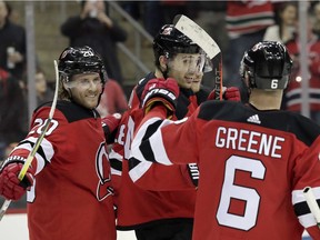 New Jersey Devils left wing Miles Wood, center, celebrates with teammates Blake Coleman (20) and Andy Greene (6) after scoring a goal against the Ottawa Senators during the second period of an NHL hockey game, Thursday, Feb. 21, 2019, in Newark, N.J.