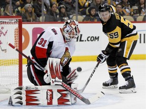 The Pittsburgh Penguins' Jake Guentzel (59) looks for a rebound as Ottawa Senators goaltender Anders Nilsson (31) makes a save during the second period of an NHL hockey game on Friday, Feb. 1, 2019, in Pittsburgh. Guentzel scored twice in the win.
