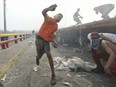 Venezuelan youths clash with the Venezuelan National Guard next to a semi-trailer that was part of a humanitarian aid convoy attempting to cross into Venezuela on the Francisco de Paula Santander international bridge in Cucuta, Colombia, Saturday, Feb. 23, 2019.