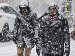 Pedestrians walk through a heavy snowfall in downtown Ottawa on March 13, 2019.
