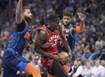 Toronto Raptors forward Pascal Siakam (43) drives to the basket between Oklahoma City Thunder forward Markieff Morris, left, and forward Paul George during Wednesday's game. (AP PHOTO)