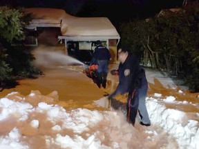 Unidentified police officer shovel and snowblow drifts that had trapped an east end Ottawa resident for months.
