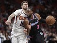 Miami Heat guard Dwyane Wade, right, dribbles the ball against Phoenix Suns guard Tyler Johnson during the second half of an NBA basketball game Monday, Feb. 25, 2019, in Miami. (AP Photo/Brynn Anderson)