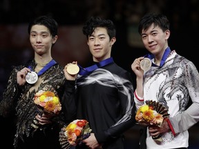 From left, Yuzuru Hanyu of Japan, Nathan Chen of the U.S. and Vincent Zhou from the U.S. display their silver, gold and bronze medals respectively after the men's free skate on Saturday at Saitama, Japan.