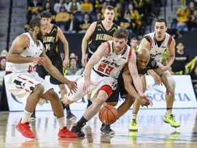Carleton's Mitch Wood, centre, and Dalhousie's Cedric Sanogo, right, fight for a loose ball during the first half of Saturday's contest in Halifax.