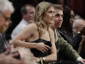 In this Feb. 15, 2017, file photo, Eugenie Bouchard, left, sits with her blind date, John Goehrke, right, during an NBA game between the Brooklyn Nets and the Milwaukee Bucks in New York. (AP Photo/Frank Franklin II, File)