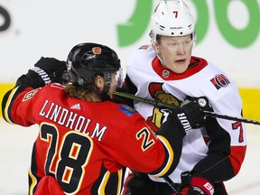 Calgary Flames’ Elias Lindholm (left) gets his stick up on Senators’ Brady Tkachuk during Thursday’s game in Calgary. The Sens are in Edmonton tonight. (AL CHAREST/POSTMEDIA NETWORK)