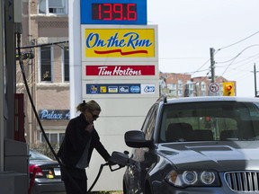 A woman pumps gas in Toronto on Tuesday, May 10, 2011.