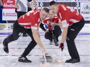 Canadian third B.J. Neufeld watches second Colton Flasch, left, and lead Ben Hebert sweep his shot during Saturday's game against South Korea at the world championship in Lethbridge.