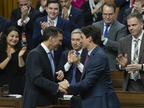 Prime Minister Justin Trudeau shakes hands with Finance Minister Bill Morneau following the delivery of the federal budget in the House of Commons on Tuesday, March 19, 2019.