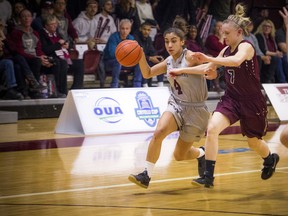 Gee-Gees’ Brooklynn McAlear-Fanus gets the ball past McMaster’s Erin Burns yesterday. The Gee-Gees lost 79-75. (Ashley Fraser/Postmedia)