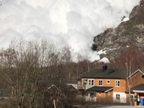 In this photo taken from amateur video, an avalanche cascades down the mountain-side towards the village of Sundal, Norway, Tuesday, March 5, 2019.